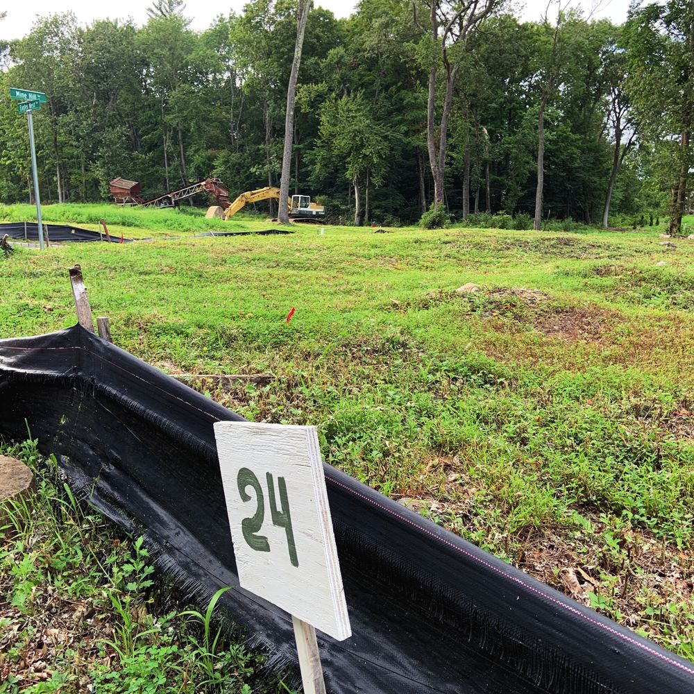 Staked building lot with a lot number sign and silt fence